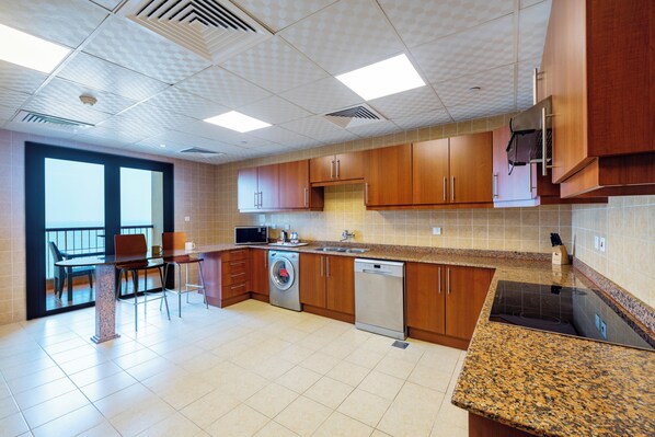 Una cocina moderna con armarios de madera, lavavajillas integrado y encimera de granito.