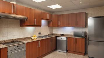 Eine moderne Küche mit Holzschränken, Edelstahlgeräten und einer Arbeitsplatte aus Granit.