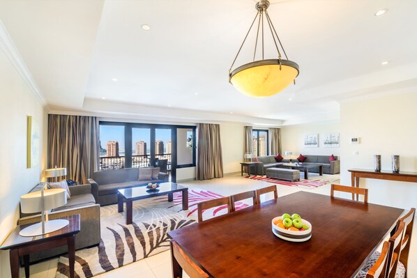 Una sala de estar moderna con comedor, ventanas amplias y vista a la ciudad.