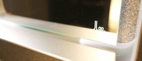 A close-up of a window with a reflection of a person and the word "Hello" on the glass.