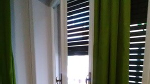 Un couloir étroit avec une porte donnant sur un balcon.