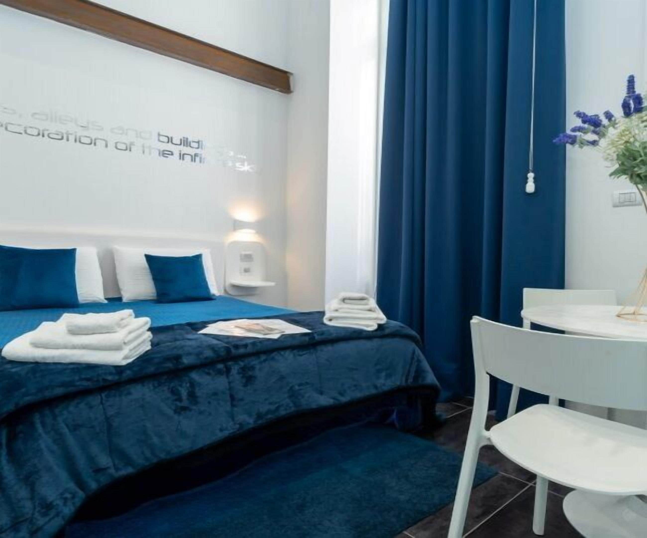 Ein modernes Hotelzimmer mit einem Bett, einem Schreibtisch und einem Stuhl.