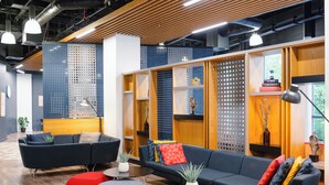 A modern lounge area with sofas, ottomans, and a coffee table. - Holiday Inn Express Birmingham - City Centre by IHG (Birmingham)
