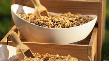 A large white bowl filled with granola on a wooden tray.