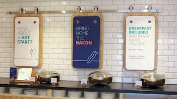 A breakfast buffet with signs indicating options like 'How about a hot start?' and 'Breakfast included and ready when you are'.