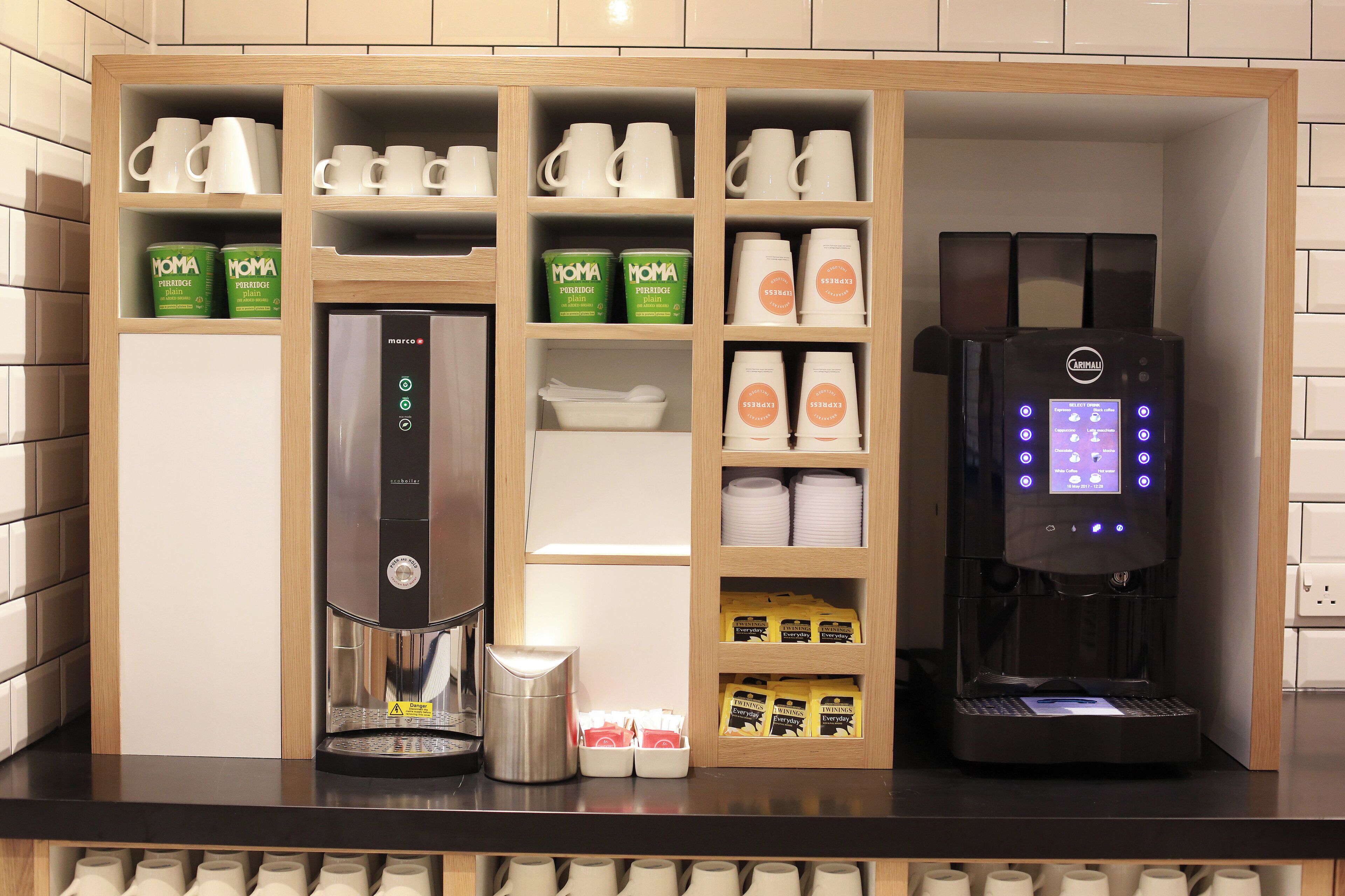 A coffee station with a coffee machine, a scale, and various coffee pods and cups.
