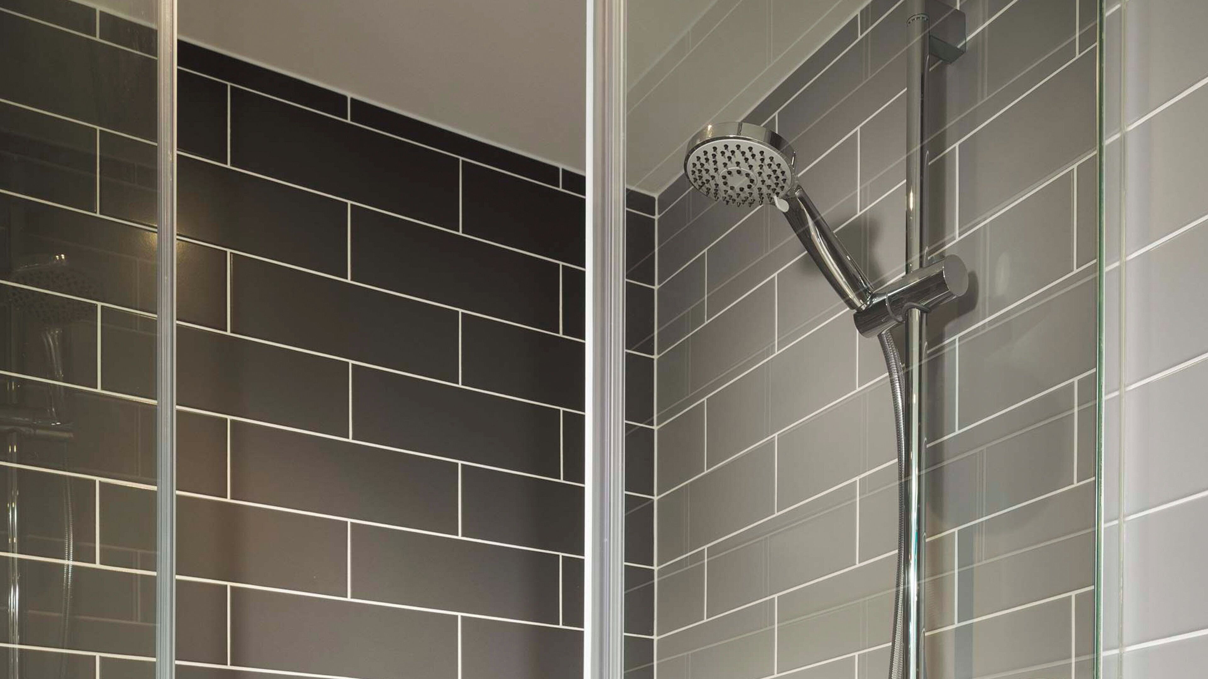 A shower with a handheld showerhead in a tiled bathroom.
