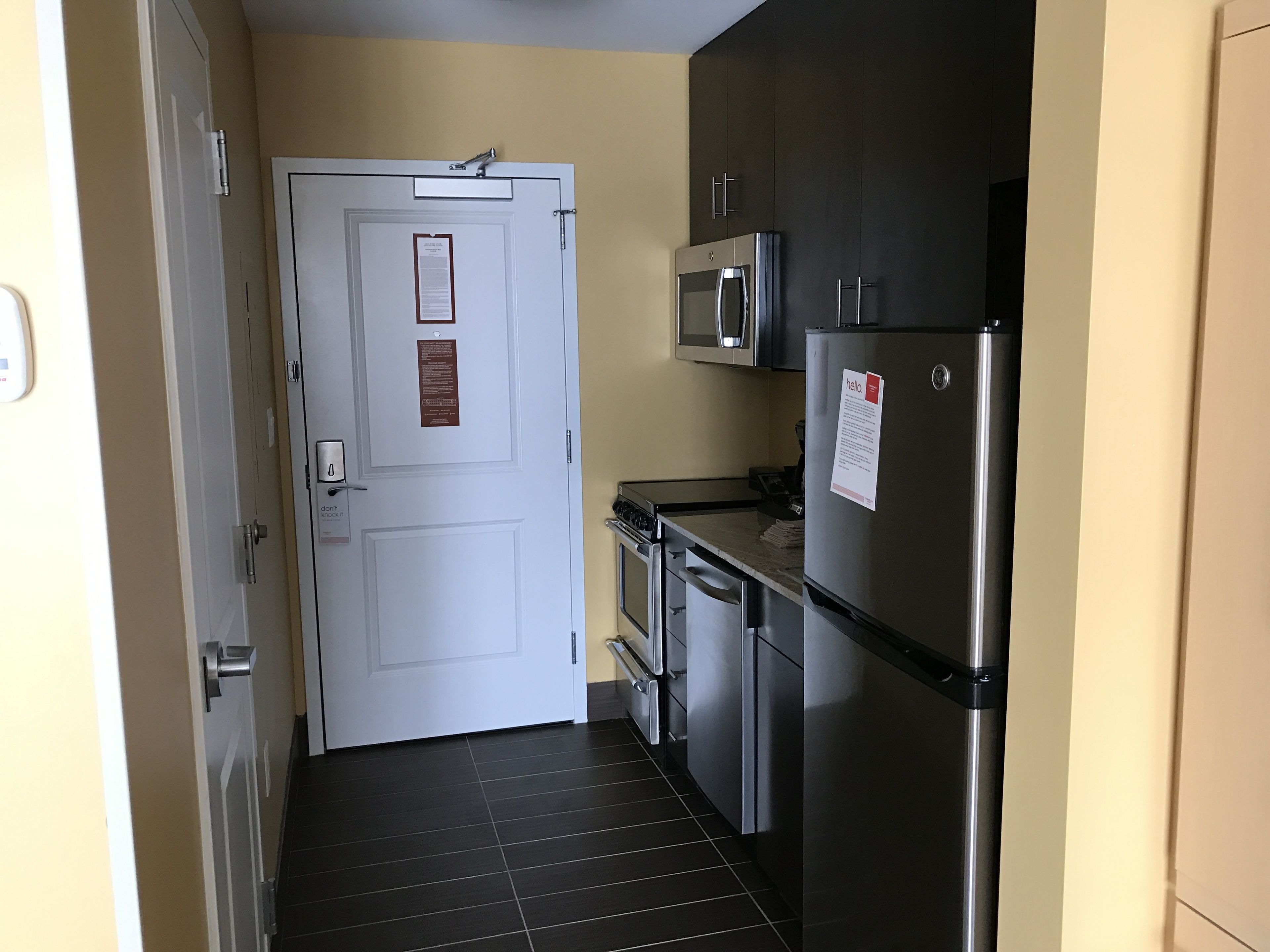 A compact kitchen with a microwave, refrigerator, and stainless steel appliances.