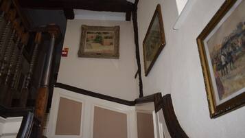 A staircase with wooden railings and a wall with framed artwork.