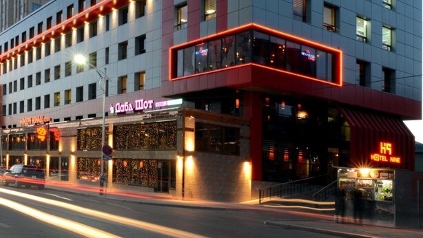 A hotel with a modern design, featuring a prominent 'HOTEL NINE' sign, a glass facade, and a red and white color scheme. - Hotel Nine (Ulaanbaatar)