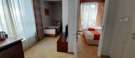 A hotel room with a bed, a desk, and a television.
