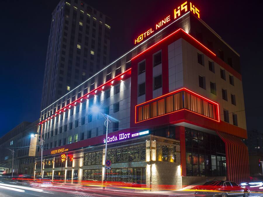 A hotel with a modern design, featuring a prominent 'HOTEL NINE' sign and a 'MOBELNIK' sign below.