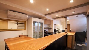 Eine moderne Küche mit Holzarbeitsplatte, eingebauten Schränken und einem Kühlschrank mit Glastür.