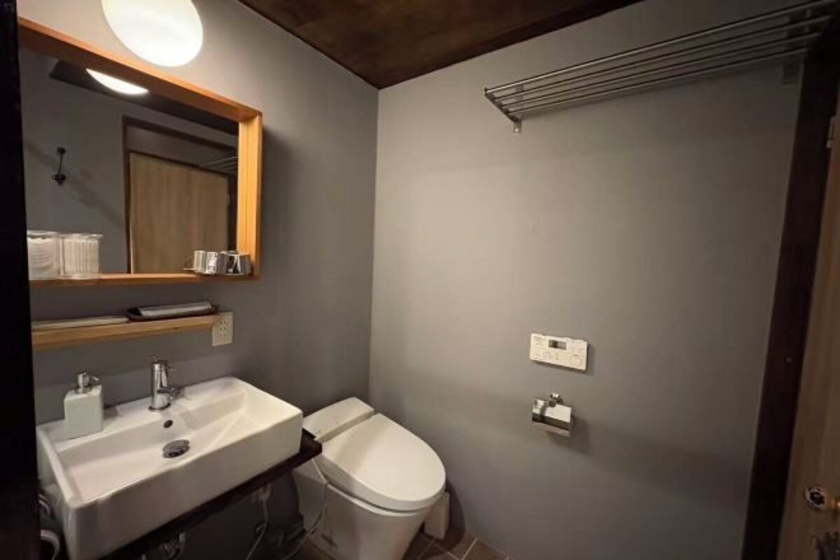 A bathroom with a sink, mirror, toilet, and towel rack.