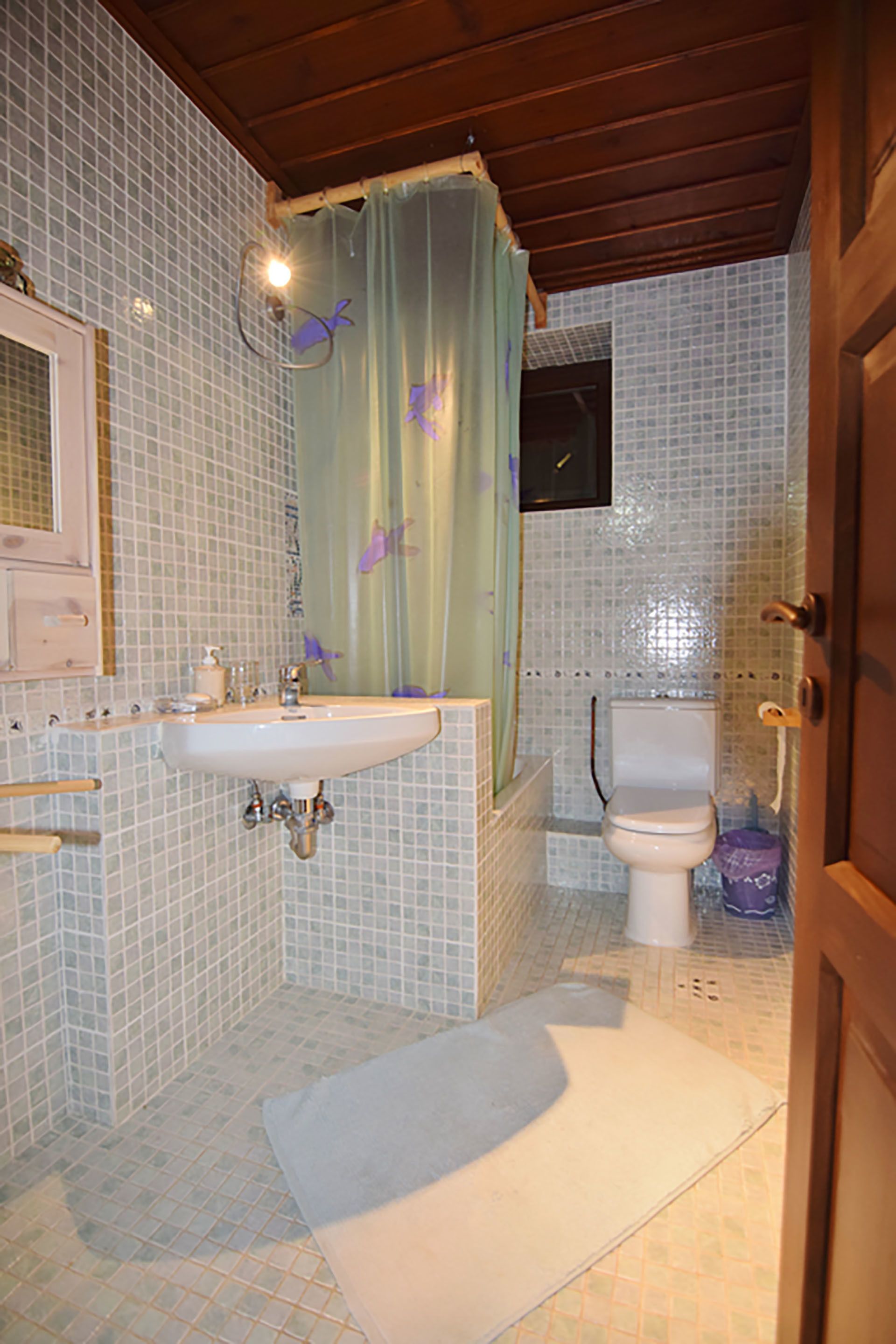 Ein Badezimmer mit Waschbecken, Toilette und Duschvorhang.