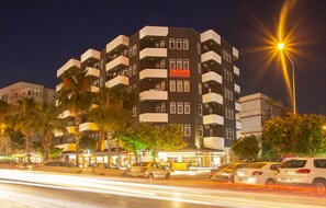 A multi-story hotel with balconies, a sign reading "ANGORA APART HOTEL," and a street with cars in motion. - Angora Apart Hotel (Alanya)