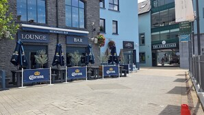 A building with a lounge and bar area, featuring Corona-branded umbrellas and signage. - The Courtyard Apartments (Carrick-on-Shannon)