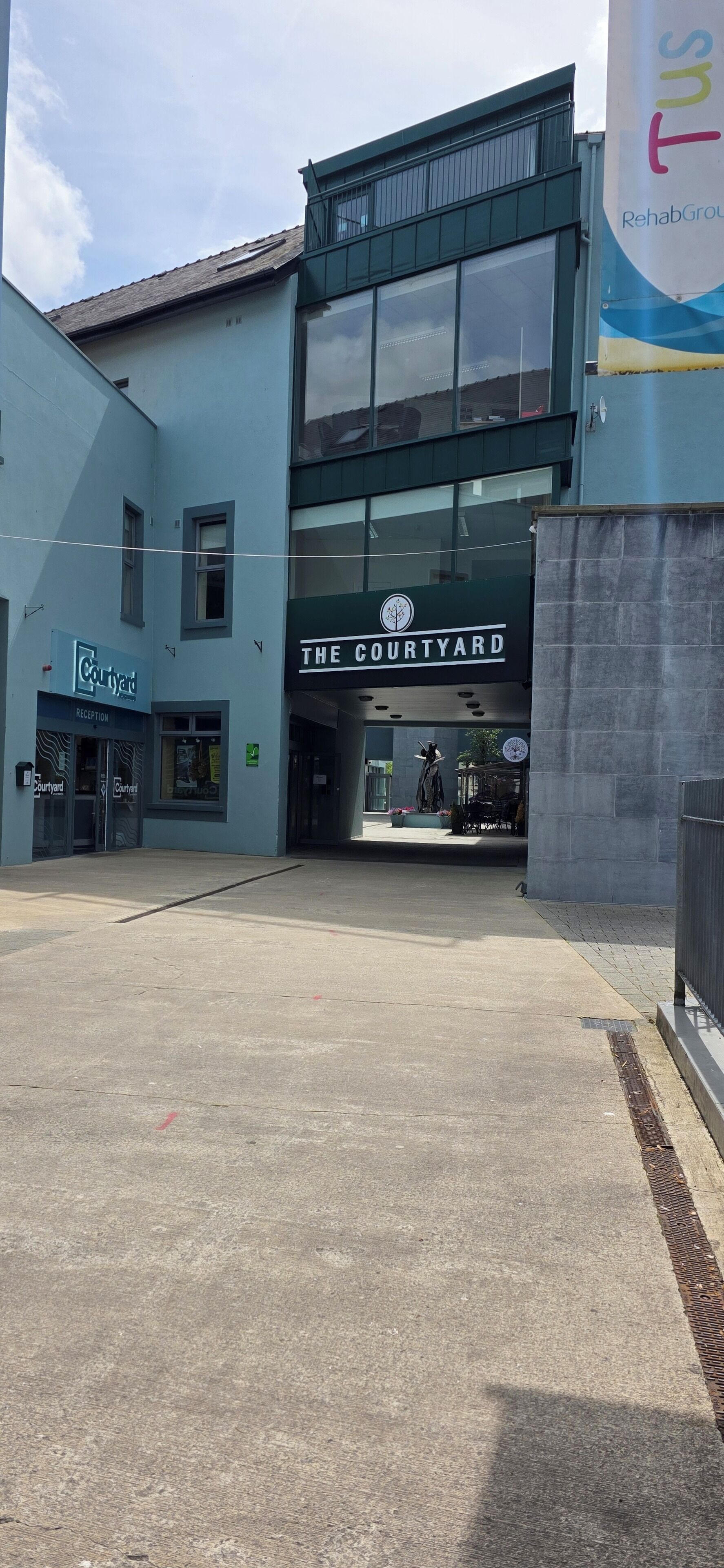 A building with a sign reading "THE COURTYARD" and another sign for "Courtyard" indicating a hotel or similar accommodation.