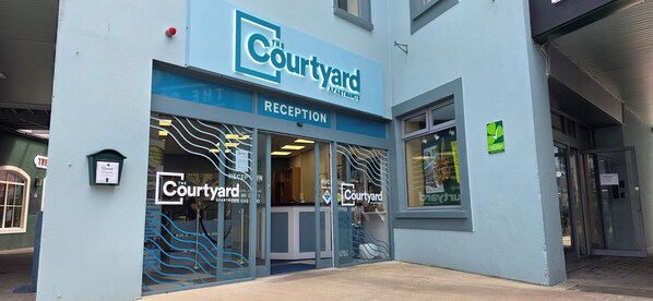 A building with a sign reading "The Courtyard Apartments" and a reception area visible through the glass doors. - The Courtyard Apartments (Carrick-on-Shannon)