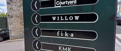 A directional sign for The Courtyard apartments with arrows pointing to various locations.