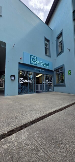 A building with a sign reading "Courtyard" and a reception area. - The Courtyard Apartments (Carrick-on-Shannon)