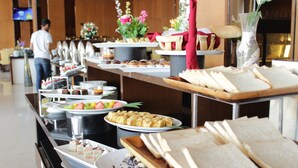 Un bufé con diversas opciones de comida y un televisor al fondo.