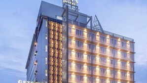 Un hotel moderno con un cartel llamativo que dice "GETS HOTEL" y una entrada bien iluminada.