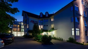A hotel with a modern design, featuring a prominent entrance, a parking area, and a well-lit facade. - Albhotel Fortuna (Riederich)