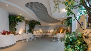 A modern interior with a curved ceiling, seating area, and indoor plants. - Hotel Fortuna (Schwaebisch Gmuend)