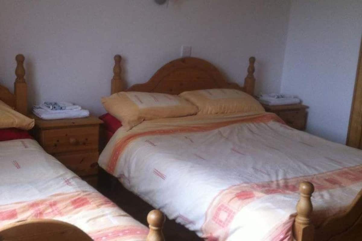 Un dormitorio con dos camas de madera, cada una con cabecero y mesita de noche.