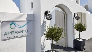 A white building with a sign reading "APERANTO SUITES SANTORINI". - Aperanto Suites (Santorini)
