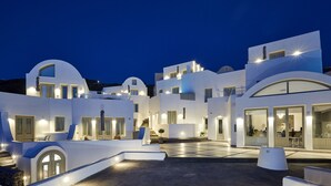 A modern white building with multiple balconies and a central courtyard. - Aperanto Suites (Santorini)