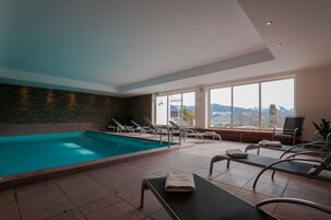 Una piscina techada, sillones reclinables de piscina