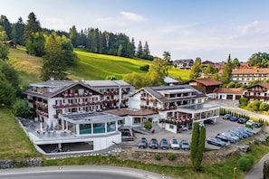 A hotel with multiple floors, a swimming pool, and a parking area. - Hotel Kuehbergalp (Blaichach)