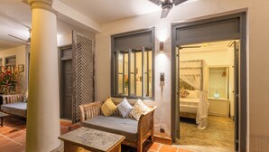 A hotel lobby with a sofa, a table, a pillar, and a doorway leading to a bathroom. - Parawa House (Galle)