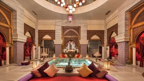 A luxurious indoor pool area with a red sofa, decorative pillows, and a fountain. - Club Privé By Rixos Belek - All Inclusive (Serik)