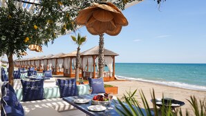 A beachside restaurant with outdoor seating, white drapes, and a view of the ocean. - Club Privé By Rixos Belek - All Inclusive (Serik)