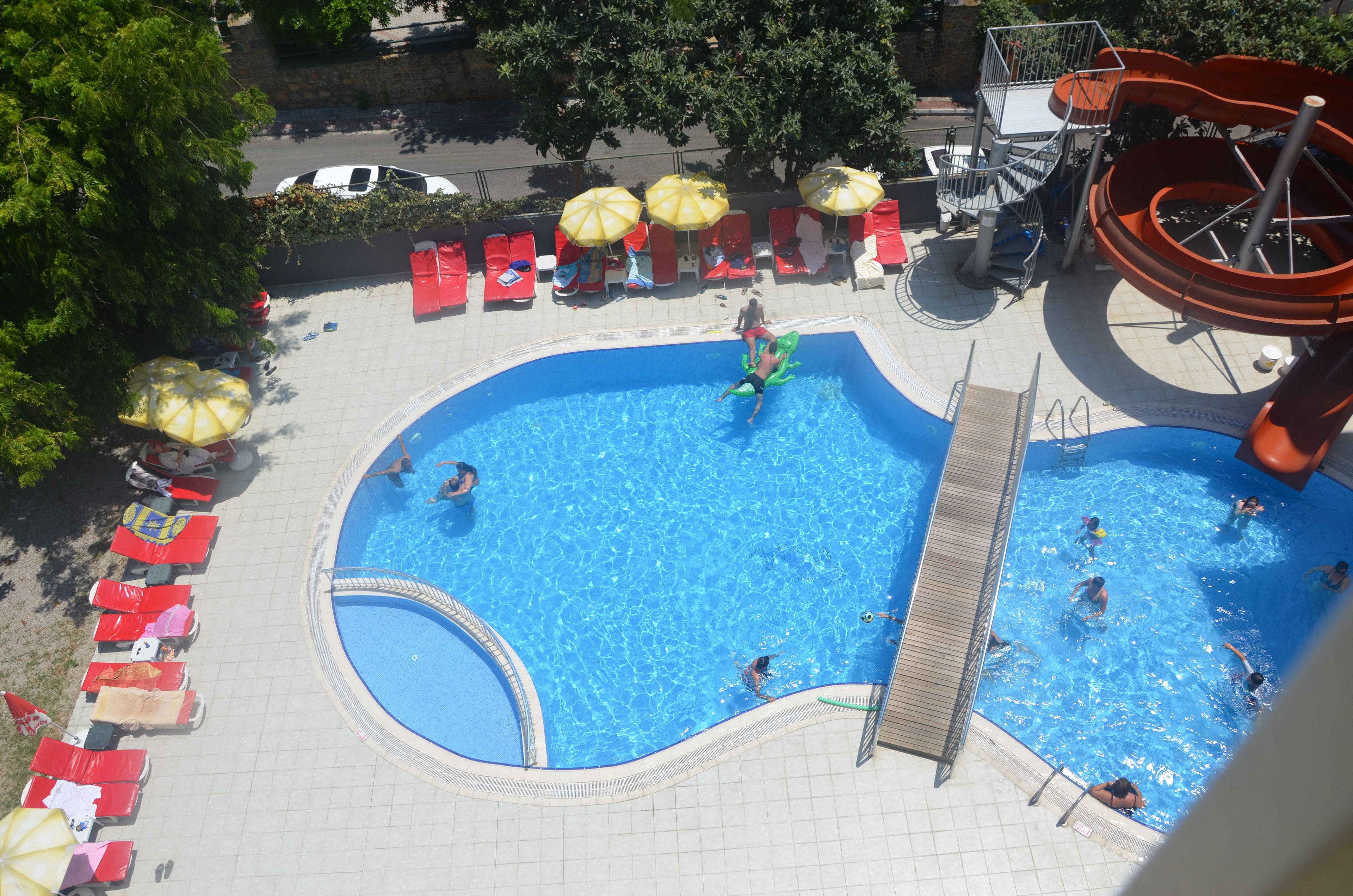 A swimming pool with multiple lanes, sun loungers, and umbrellas.