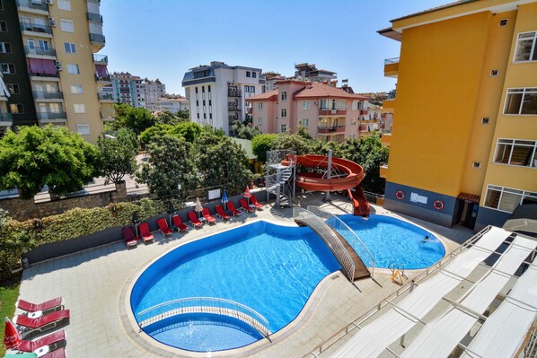 Alberca al aire libre, sombrillas en la alberca y camastros 