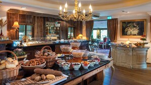 Disposição de buffet com diversos alimentos e um candelabro.