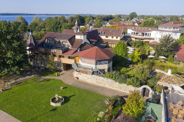 A large estate with multiple buildings, a well-maintained lawn, and a view of a lake. - Wellnesshotel Seeschlößchen (Senftenberg)