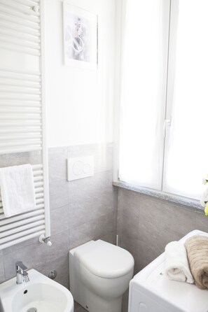 Un baño moderno con inodoro, lavamanos y toallero.