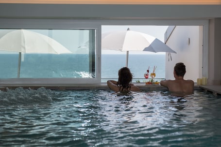 Una piscina techada, una piscina en la azotea, sombrillas. Hesperia Hotel & Residence