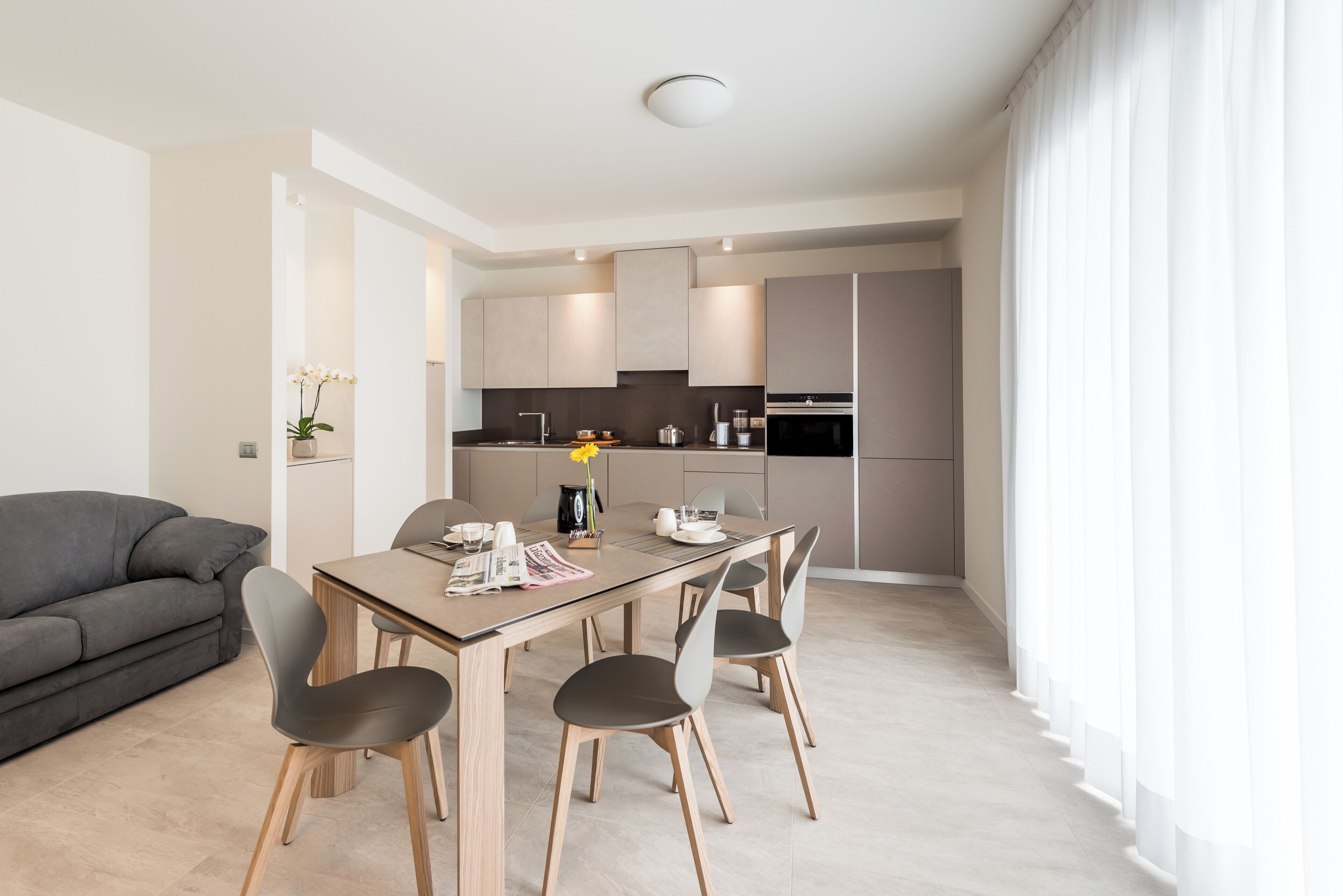 Une cuisine moderne avec un coin repas, comprenant une table en bois, des chaises et un canapé.