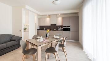 Une cuisine moderne avec un coin repas, comprenant une table en bois, des chaises et un canapé.