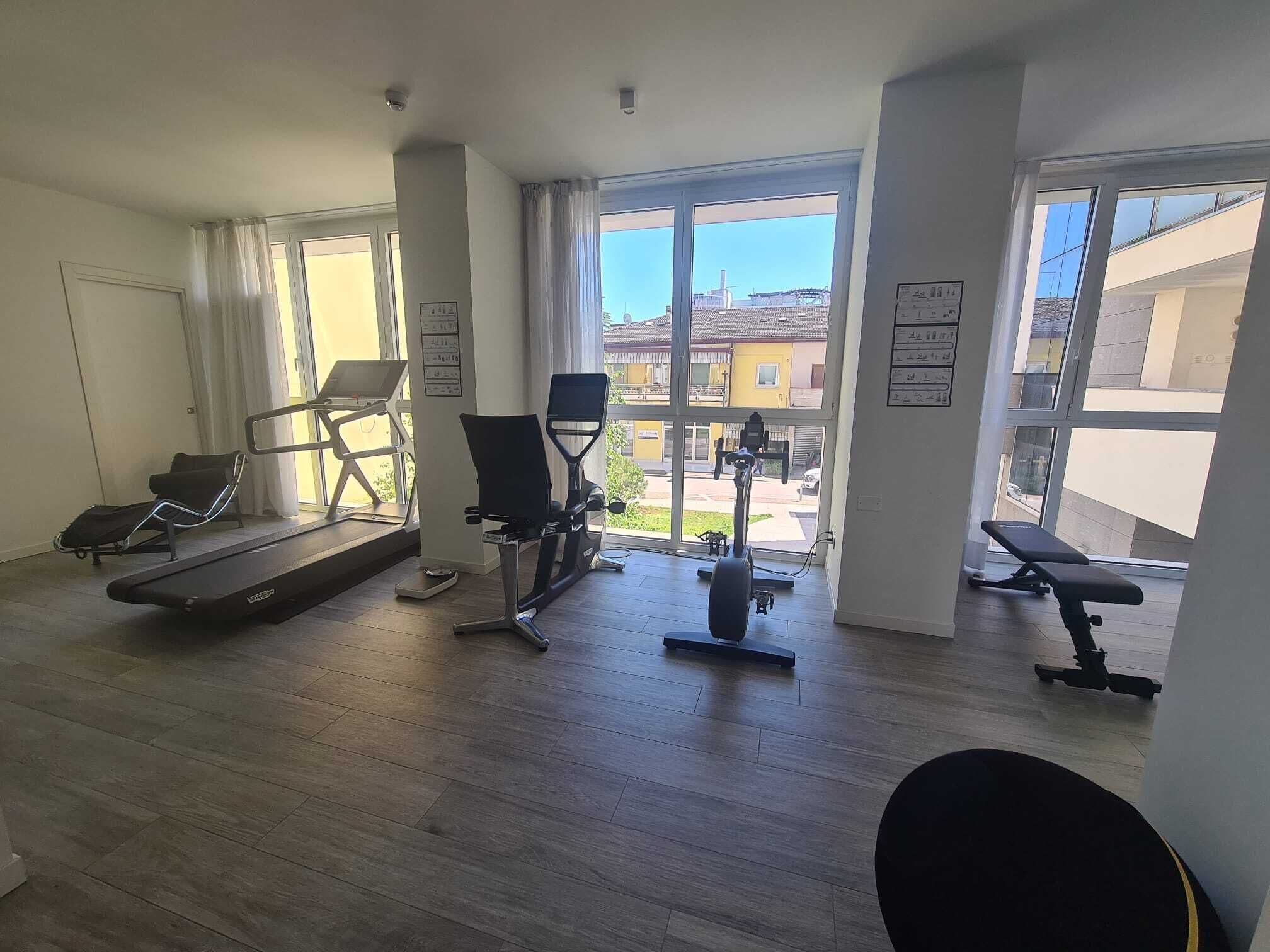 A spacious gym with a treadmill, elliptical, and stationary bike.