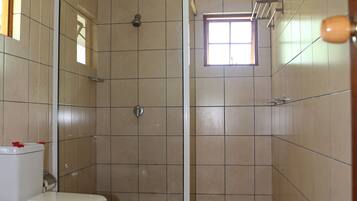 A bathroom with a shower, toilet, and bidet.