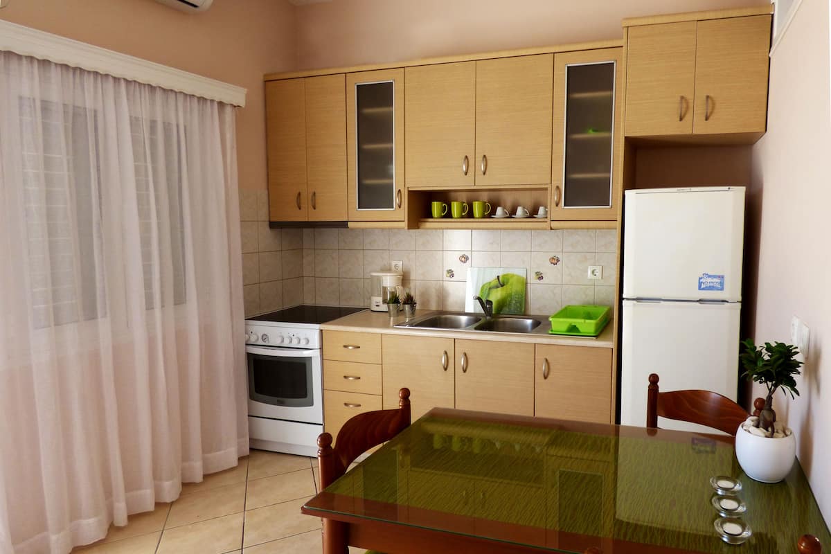 A kitchen with wooden cabinets, a stove, a sink, and a refrigerator.