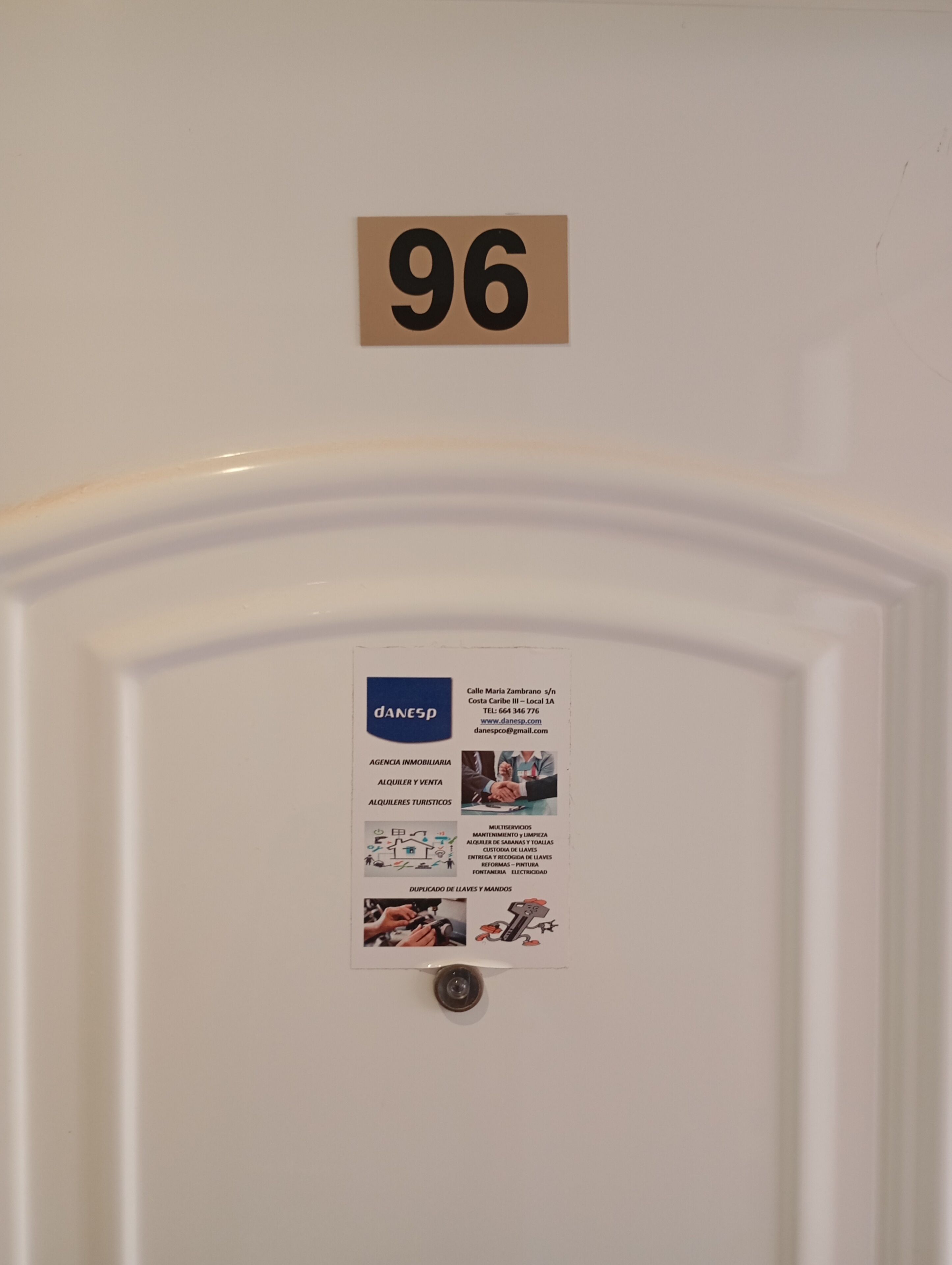 Une porte avec une pancarte indiquant le numéro de la pièce (96), un numéro de téléphone et une liste des services offerts, notamment les services d’agence, de vente et d’assistance aux touristes.