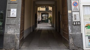 A building entrance with a covered passageway, a balcony with metal railings, and a no parking sign. - Alessia's Flat - Paolo Sarpi (Milan)